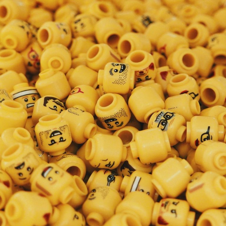 Yellow Lego Heads A collection of yellow LEGO heads with various facial expressions.